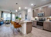 Thumbnail 1 of 41 - a kitchen with a large center island with a breakfast bar and a living room in the background