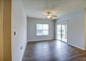 Thumbnail 20 of 29 - a living room with a ceiling fan and a sliding glass door