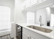Thumbnail 13 of 33 - a kitchen with white cabinets and a sink and a window