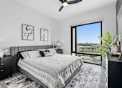 Thumbnail 20 of 35 - A bedroom with a large bed and a view of the outside.