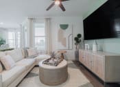 Thumbnail 15 of 43 - a living room with a large white couch and a large tv on the wall