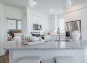 Thumbnail 18 of 43 - a kitchen with white cabinets and a granite counter top
