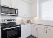Thumbnail 19 of 43 - a kitchen with white cabinets and black appliances
