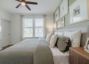 Thumbnail 28 of 43 - a bedroom with a large bed and a ceiling fan