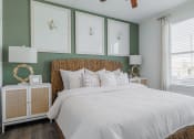 Thumbnail 22 of 43 - a bedroom with green walls and a white bedspread and rattan headboard