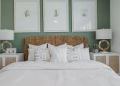 Thumbnail 23 of 43 - a bedroom with green walls and a white bedspread and rattan headboard