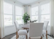 Thumbnail 29 of 43 - a dining room with white walls and a wooden table with white chairs