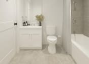 Thumbnail 12 of 19 - A white bathroom with a toilet, sink, and bathtub.