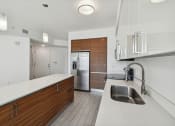 Thumbnail 62 of 66 - a kitchen with white countertops and wooden cabinets