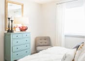 Thumbnail 9 of 34 - a bedroom with a bed and a chair and a dresser