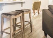 Thumbnail 3 of 34 - a bar with two stools in a living room with a couch