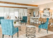 Thumbnail 21 of 34 - a living room with blue chairs and a dining table