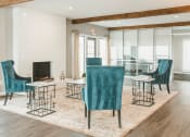 Thumbnail 20 of 34 - a living room with blue chairs and a fireplace