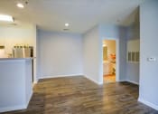 Thumbnail 21 of 29 - an empty living room and kitchen with a wood floor
