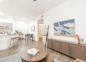 Thumbnail 4 of 20 - a living room and kitchen with a table and a painting on the wall