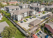 Thumbnail 20 of 28 - Apartment complex with a parking lot in front.
