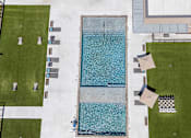 Thumbnail 14 of 31 - A large rectangular pool with a blue tiled edge and a person sitting on the edge.
