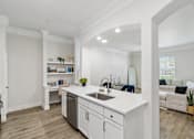 Thumbnail 2 of 42 - A modern kitchen with white cabinets and a large island.