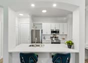 Thumbnail 5 of 42 - A modern kitchen with white cabinets and a center island.