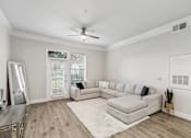 Thumbnail 8 of 42 - A spacious living room with a white couch and a rug on the floor.