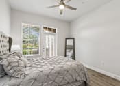 Thumbnail 11 of 42 - A bedroom with a large bed and a ceiling fan.