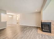 Thumbnail 10 of 22 - A room with a fireplace and wood flooring.