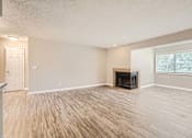Thumbnail 9 of 22 - A living room with a fireplace and hardwood floors.