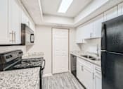 Thumbnail 1 of 22 - A kitchen with black appliances and white cabinets.