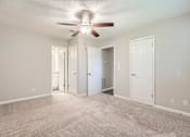Thumbnail 12 of 22 - A room with a ceiling fan and carpeted floor.