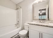 Thumbnail 17 of 22 - A white bathroom with a toilet, sink, and bathtub.