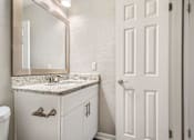 Thumbnail 18 of 22 - A bathroom with a sink, mirror, and toilet.