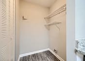 Thumbnail 14 of 22 - A small, empty room with a marble countertop and wood flooring.