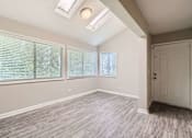 Thumbnail 11 of 22 - A room with a white door, two windows with blinds, and a skylight.