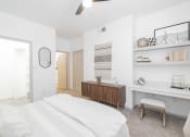 Thumbnail 7 of 26 - a bedroom with a white bed and a wooden dresser