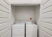 Thumbnail 28 of 57 - A white laundry room with a washer and dryer.