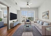 Thumbnail 7 of 34 - A modern living room with a large window and a ceiling fan.