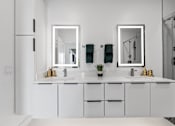 Thumbnail 22 of 35 - A white bathroom with two sinks and two mirrors.