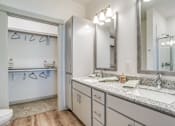 Thumbnail 10 of 50 - A bathroom with a sink, mirror, and a white door.