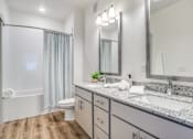 Thumbnail 9 of 50 - A bathroom with a white tub, sink, and mirror.