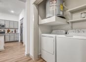 Thumbnail 12 of 37 - a washer and dryer in a laundry room with a kitchen in the background