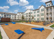 Thumbnail 21 of 37 - an outdoor playground with benches and picnic tables in front of an apartment building