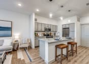Thumbnail 4 of 37 - a kitchen and living room with an island and stools