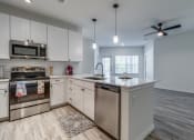 Thumbnail 24 of 65 - an open kitchen with stainless steel appliances and white cabinets