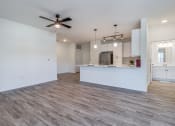 Thumbnail 27 of 65 - an empty living room and kitchen with a ceiling fan