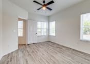 Thumbnail 36 of 65 - an empty living room with a ceiling fan and windows