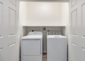 Thumbnail 38 of 65 - a washer and dryer in a laundry room with white walls and white doors