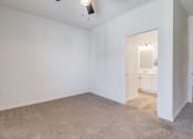 Thumbnail 15 of 65 - a bedroom with white walls and carpet and a door to a bathroom