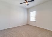 Thumbnail 12 of 65 - an empty bedroom with a ceiling fan and a window