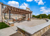 Thumbnail 52 of 65 - a patio with a stone wall and a wooden pergola