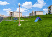 Thumbnail 54 of 65 - a playground on the grass with apartments in the background